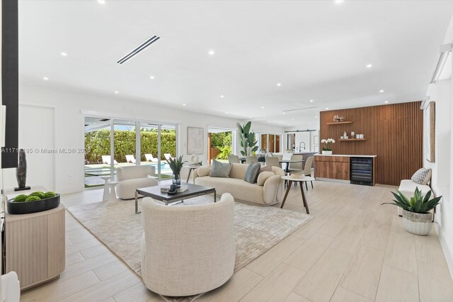 kitchen with a kitchen bar, sink, gray cabinetry, stainless steel appliances, and a kitchen island with sink