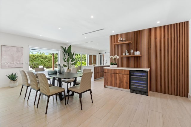 dining space with light wood-style floors, beverage cooler, and recessed lighting