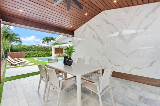 view of patio with a fenced in pool, outdoor dining space, ceiling fan, and fence