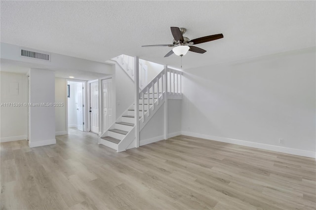 interior space with ceiling fan, hardwood / wood-style floors, and a textured ceiling