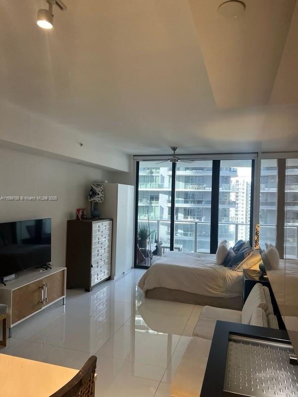 tiled bedroom with multiple windows and a wall of windows