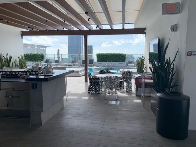 view of patio / terrace featuring a community pool, exterior bar, and a pergola