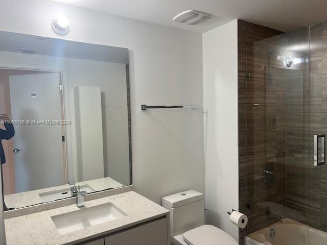 full bathroom with vanity, combined bath / shower with glass door, and toilet