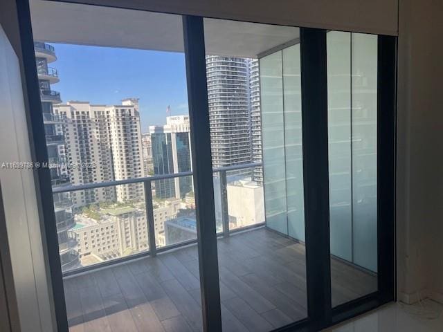 interior space featuring wood-type flooring, floor to ceiling windows, and a healthy amount of sunlight