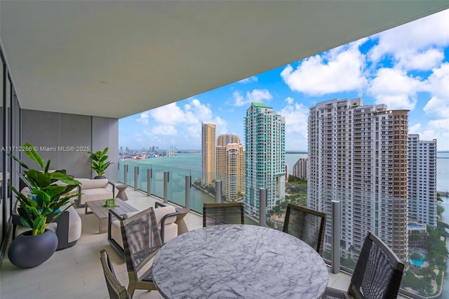 balcony with a water view and an outdoor hangout area