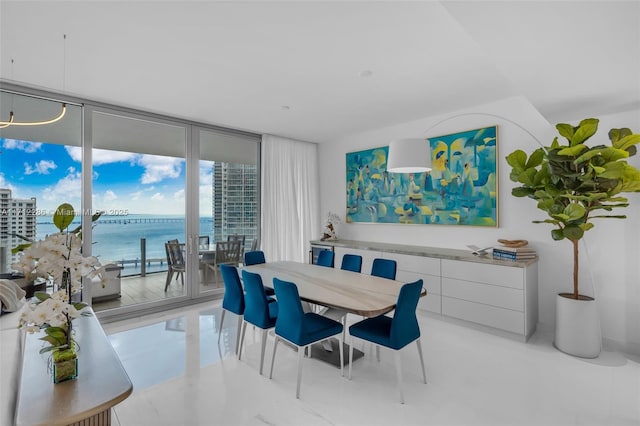 dining space with a water view and expansive windows