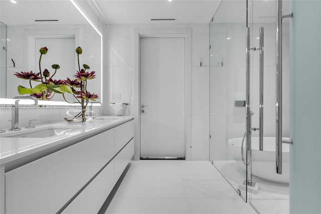 bathroom with tile patterned flooring, vanity, and walk in shower