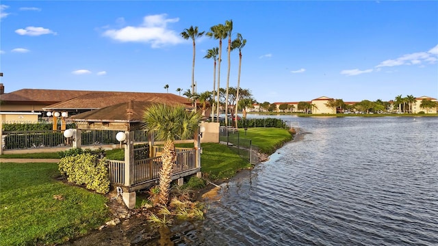 view of home's community with a lawn and a water view