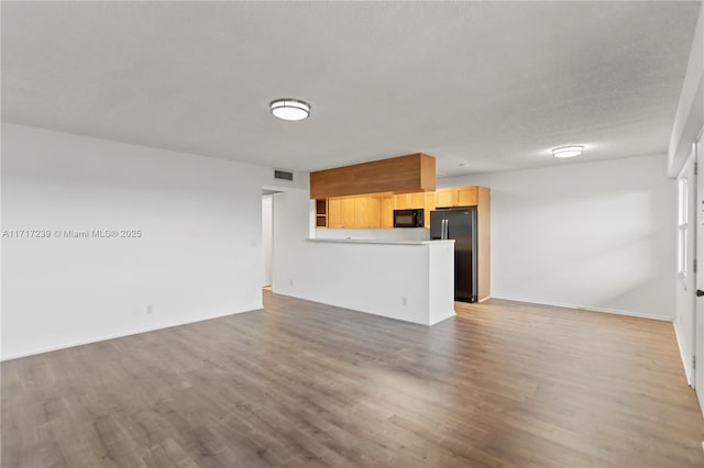 unfurnished living room with a textured ceiling and hardwood / wood-style flooring