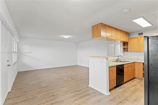 kitchen with kitchen peninsula, sink, black appliances, and light hardwood / wood-style floors