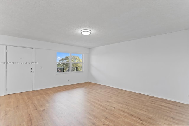 unfurnished room with light hardwood / wood-style floors and a textured ceiling