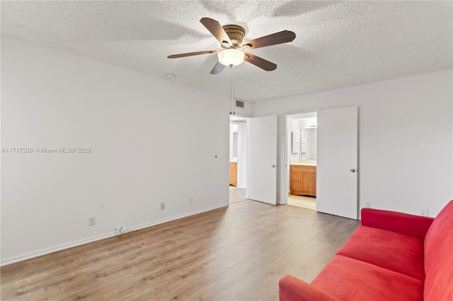 living room featuring ceiling fan, a textured ceiling, and hardwood / wood-style flooring