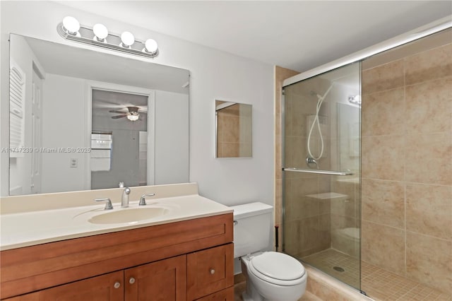 bathroom with an enclosed shower, vanity, ceiling fan, and toilet