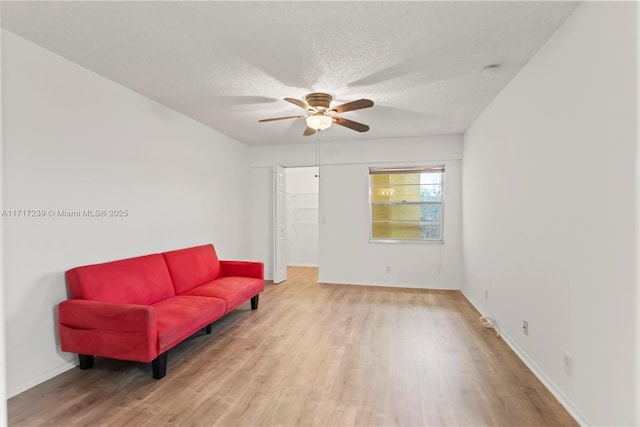 sitting room with a textured ceiling, light hardwood / wood-style floors, and ceiling fan