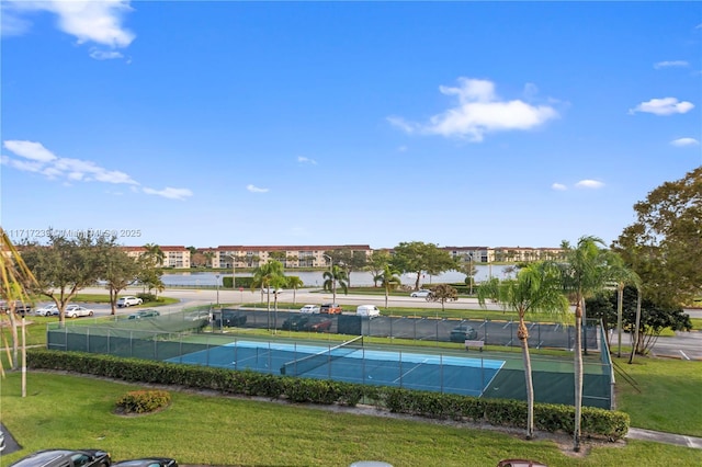 view of tennis court with a lawn