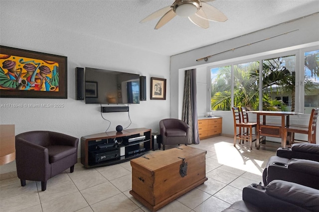 living room with ceiling fan, light tile patterned floors, and a textured ceiling