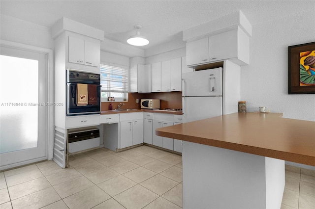 kitchen featuring kitchen peninsula, white cabinets, and white appliances