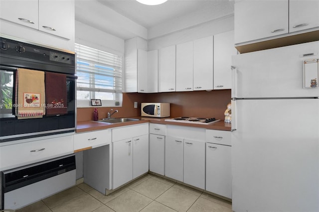 kitchen with white cabinets, white appliances, light tile patterned flooring, and sink