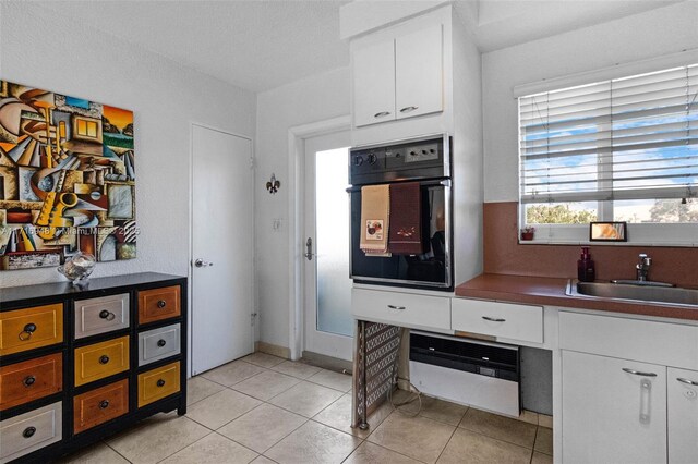 1000 SE 4th St Unit 312, Fort Lauderdale, FL 33301 - kitchen featuring black oven, a sink, white cabinets, and dark countertops