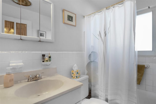 full bathroom featuring vanity, a healthy amount of sunlight, toilet, and shower / tub combo with curtain