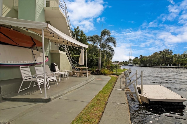 view of patio / terrace with a water view and a dock