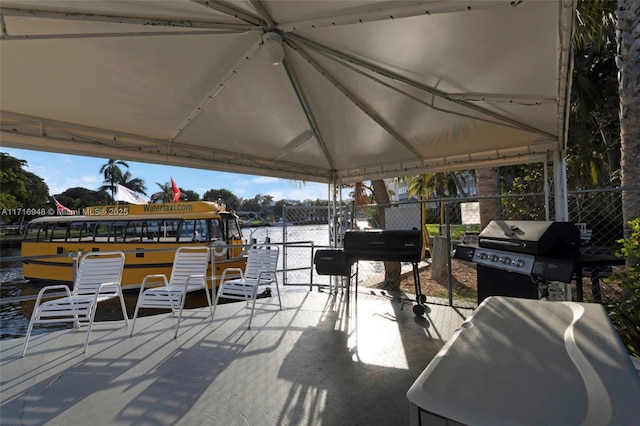 view of patio with a gazebo, a water view, and area for grilling