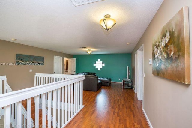 hallway featuring a textured ceiling and dark hardwood / wood-style floors