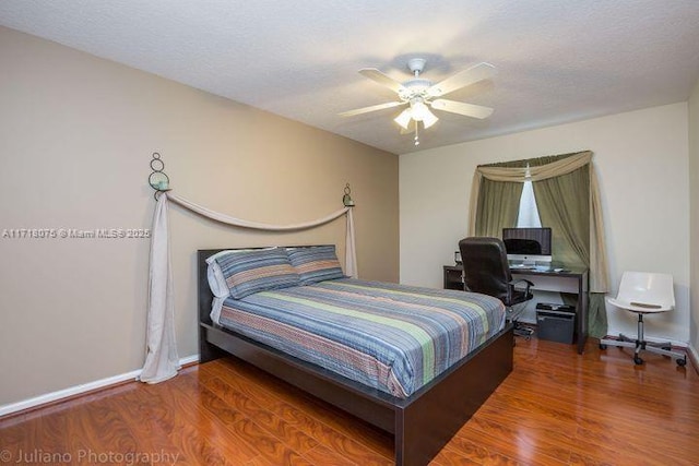 bedroom with ceiling fan, hardwood / wood-style floors, and a textured ceiling