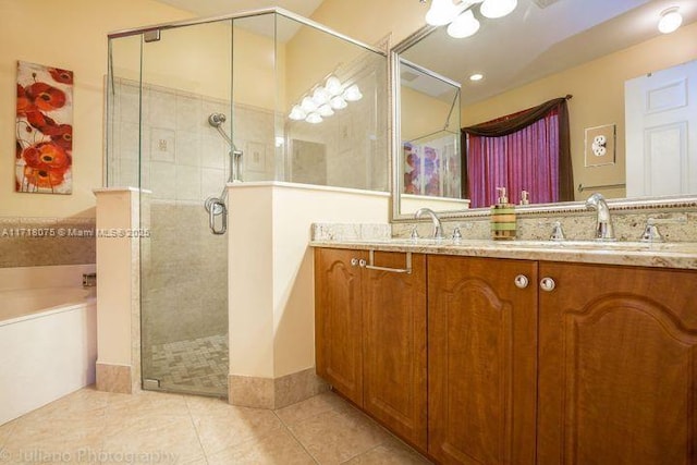 bathroom featuring plus walk in shower, vanity, and tile patterned flooring