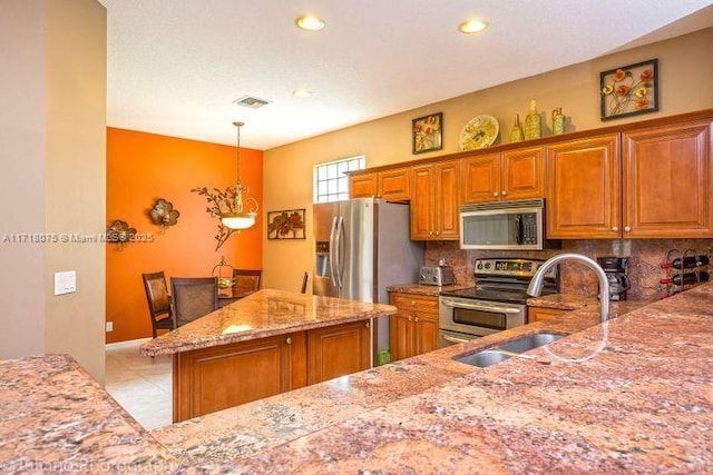 kitchen with decorative light fixtures, tasteful backsplash, sink, appliances with stainless steel finishes, and light tile patterned floors