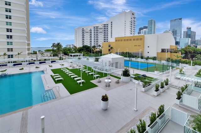 view of swimming pool featuring a patio and tennis court