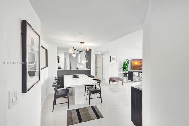 dining area featuring light tile patterned flooring and an inviting chandelier