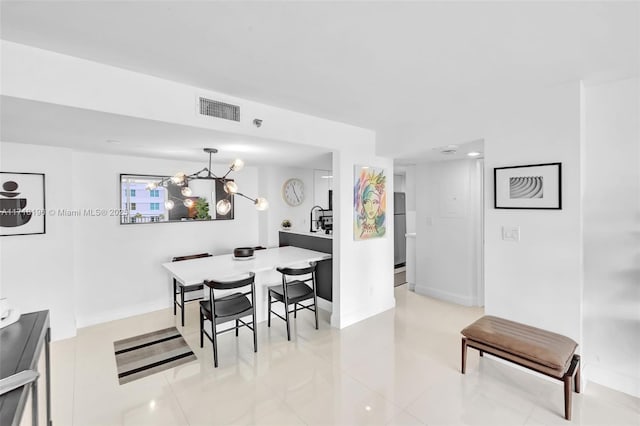 tiled dining room with an inviting chandelier