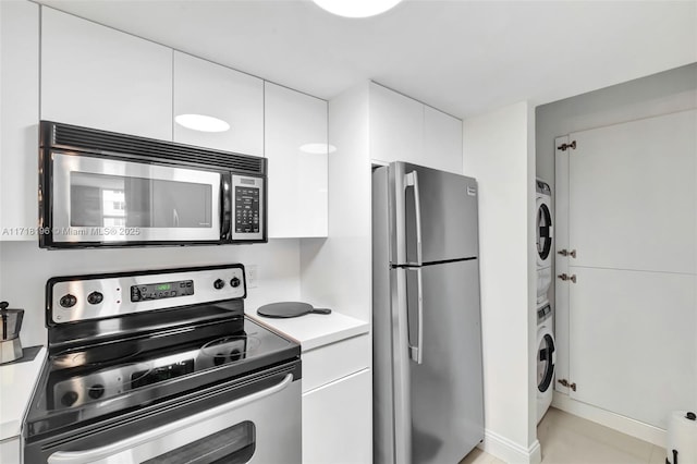 kitchen with white cabinets, stainless steel appliances, and stacked washing maching and dryer