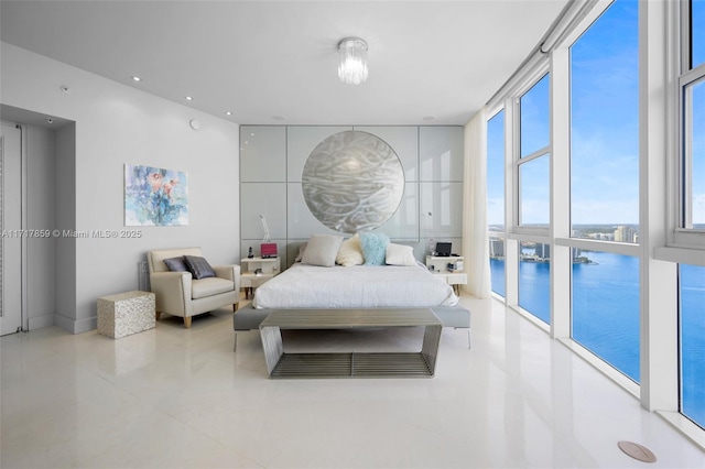 bedroom with a water view and a wall of windows