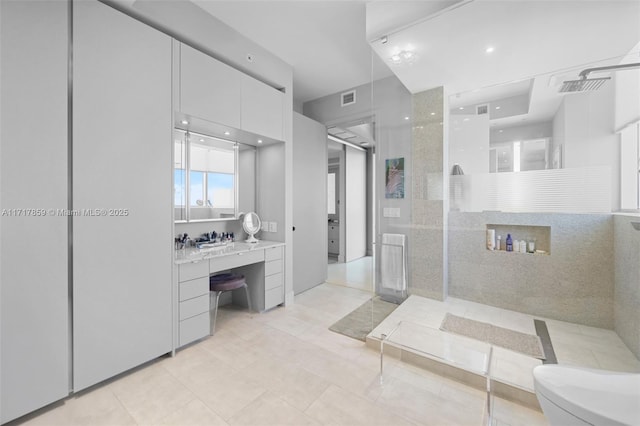 bathroom featuring tile patterned floors, vanity, toilet, and walk in shower