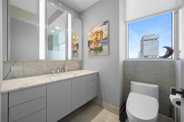 bathroom with decorative backsplash, vanity, and toilet