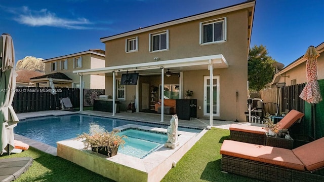 back of property featuring a swimming pool with hot tub and a patio area