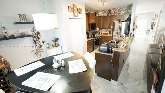 kitchen featuring backsplash, stainless steel appliances, and light stone counters