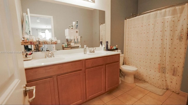 bathroom featuring tile patterned flooring, vanity, toilet, and walk in shower