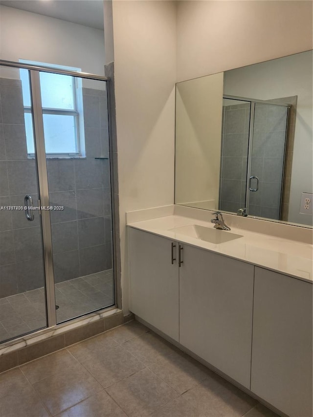 bathroom with tile patterned floors, vanity, and a shower with door