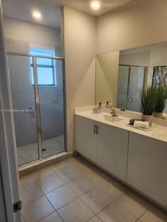 bathroom with tile patterned flooring, vanity, and a shower with door