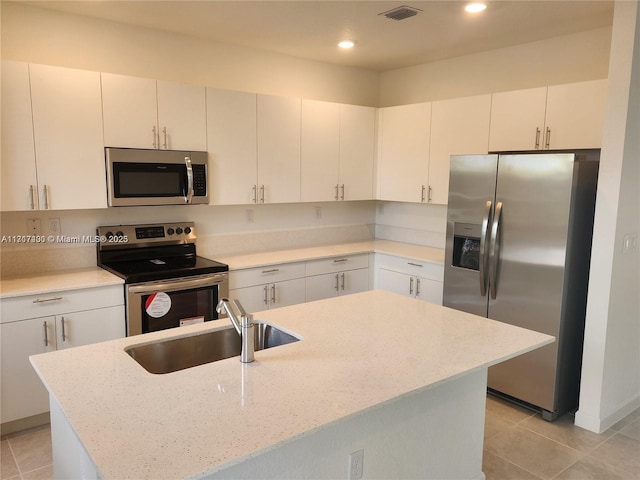 kitchen with white cabinets, sink, an island with sink, and stainless steel appliances