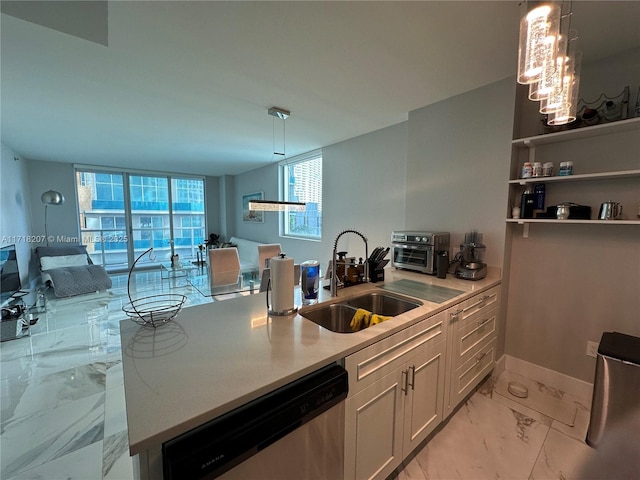 kitchen with stainless steel dishwasher, a wealth of natural light, sink, and hanging light fixtures