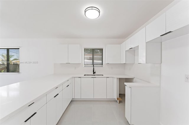 kitchen with sink, light tile patterned floors, a wealth of natural light, and white cabinets