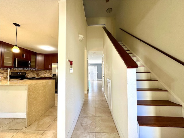 staircase with tile patterned floors and sink