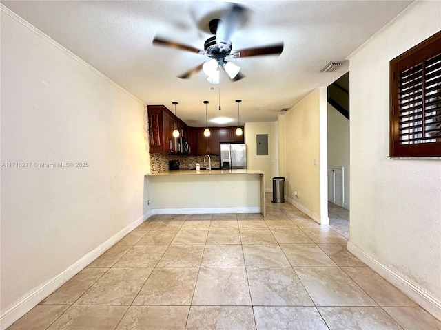 kitchen with sink, stainless steel refrigerator with ice dispenser, kitchen peninsula, electric panel, and decorative backsplash