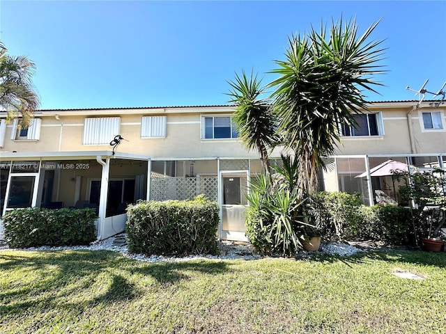 back of property featuring a lawn