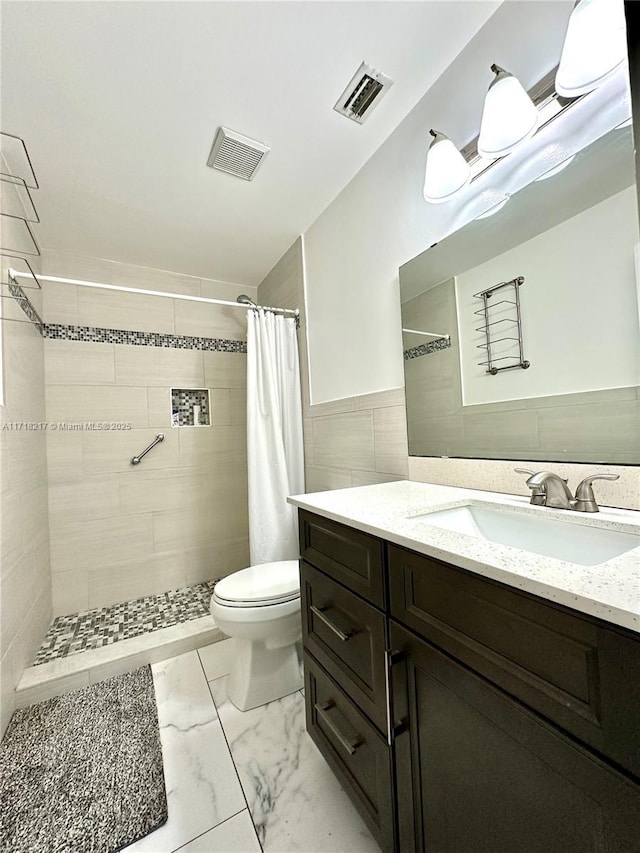 bathroom with a shower with shower curtain, vanity, toilet, and tile walls