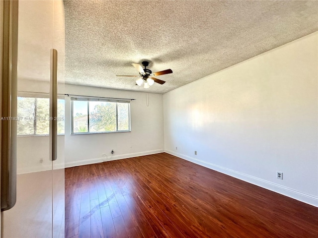 empty room with a textured ceiling, ceiling fan, and dark wood-type flooring